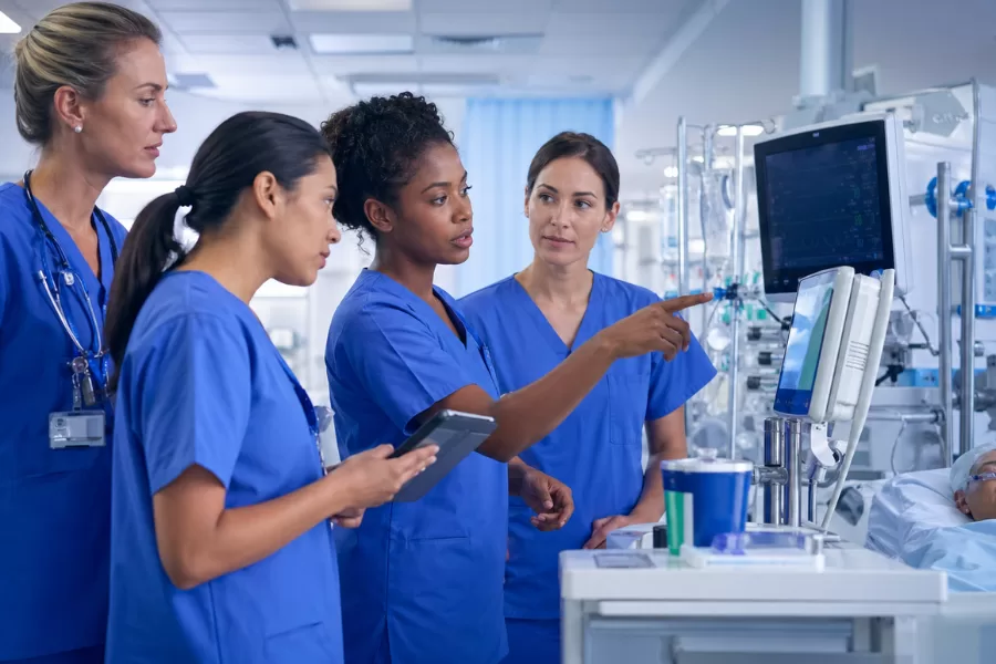 Carreira Hospitalar na Enfermagem: Guia Prático para Começar e Evoluir Equipe de enfermagem na UTI analisando monitores e equipamentos em ambiente hospitalar moderno