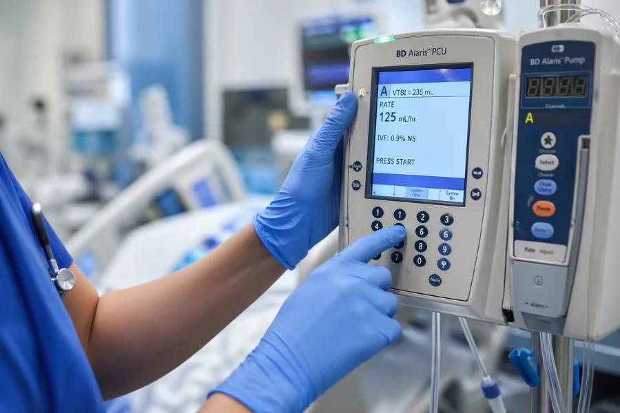 Técnico de enfermagem na UTI: o que faz, perfil e oportunidades Técnico de enfermagem na UTI ajustando bomba de infusão com precisão em ambiente de terapia intensiva